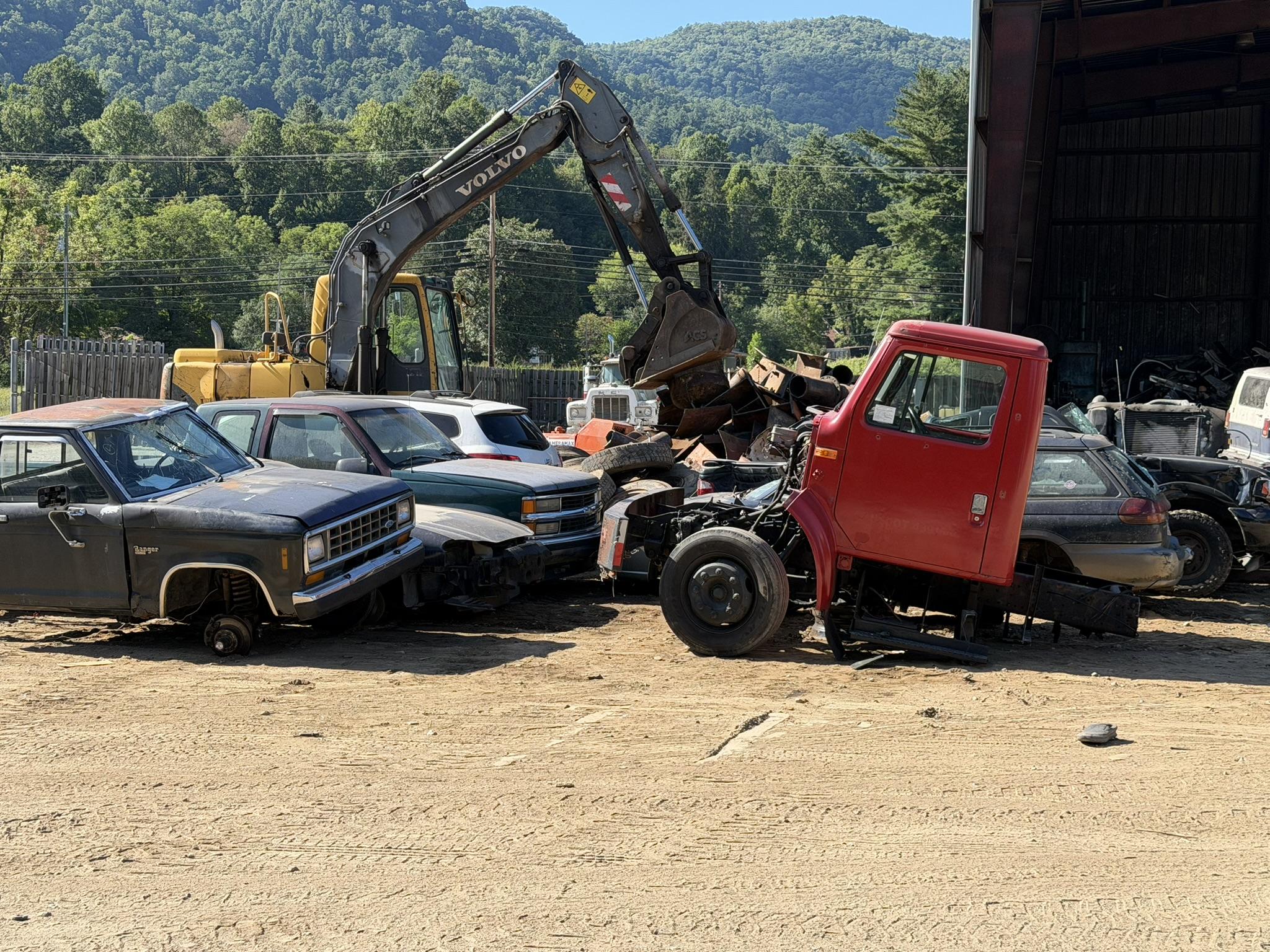 A material handler working the vehicle row at the Metalwood Recycling yard in Sylva