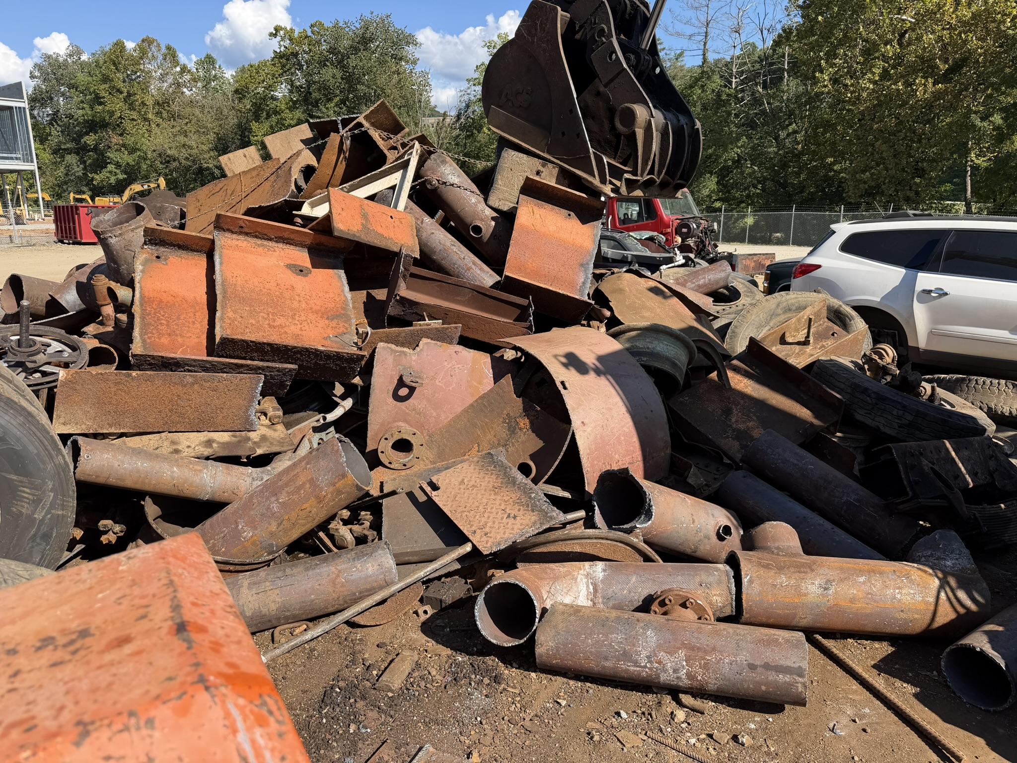 A pile of heavy iron — pipe, plate and tanks — waiting to be sheared to length